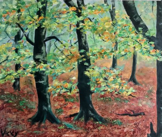 Bosque con árboles verdes y marrones, suelo cubierto de hojas secas.